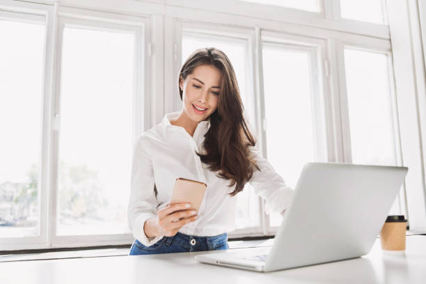 Beautiful content creator woman using laptop and smart phone, tax-efficient money investment strategies