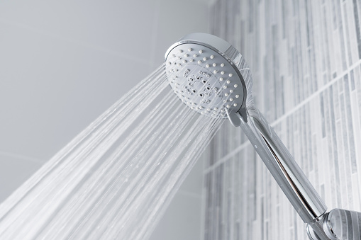 Agua que corre desde el cabezal de ducha y el grifo en el baño moderno. photo