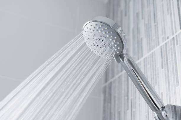 água que funciona da cabeça e do faucet de chuveiro no banheiro moderno. - shower - fotografias e filmes do acervo