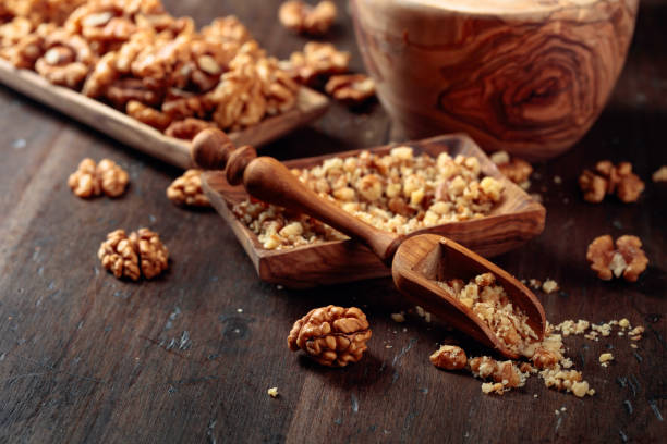 istock Walnuts in a wooden dish on an old wooden table. 1176126621