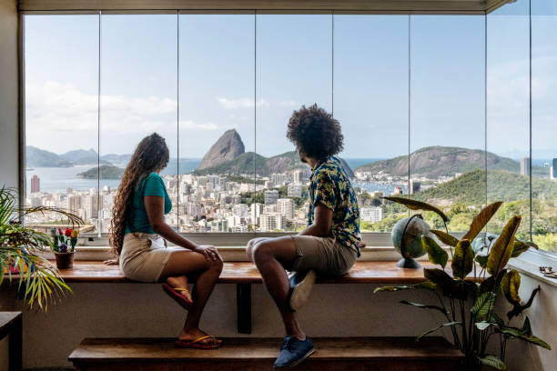 para siedząca przy oknie i patrząca na widok rio de janiro - rio de janeiro sugarloaf mountain brazil sugarloaf zdjęcia i obrazy z banku zdjęć