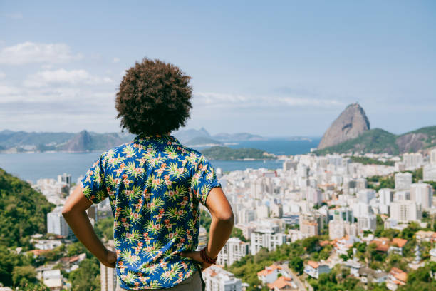 Man with hands on hips, looking at view, Sugarloaf Mountain in background, on vacation