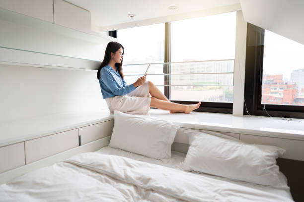 istock Young Asian woman using digital tablet by the window 1176127118