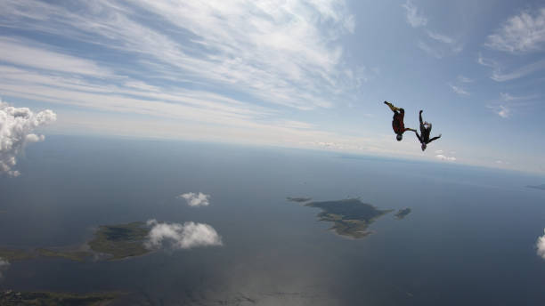 istock Skydivers fall through clear skies, in aerial flight 1176130887