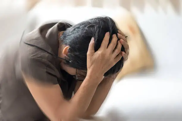 Photo of Vertigo illness concept. Old woman hands on her head felling headache dizzy sense of spinning dizziness,a problem with the inner ear, brain, or sensory nerve pathway.