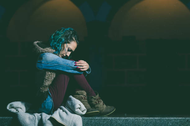 Lonely and sad girl seated sitting on a bench