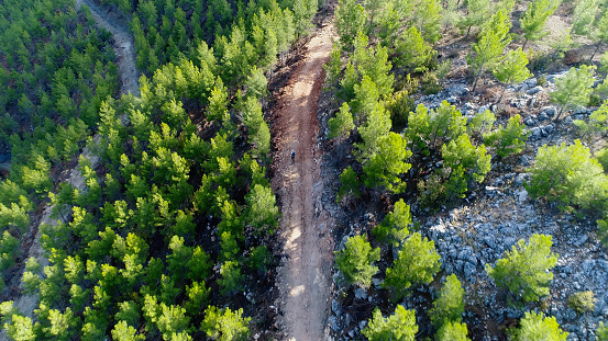Mountain Biker Riding on a dirt road aerial view.