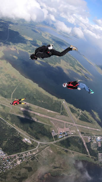 skydivers spaść przez bezchmurne niebo, w locie powietrznym - skydiving air aerial view vertical zdjęcia i obrazy z banku zdjęć