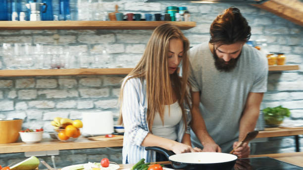 istock Young couple making dinner together at home 1176135344
