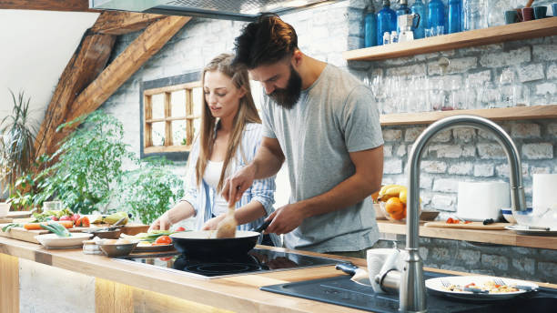istock Young couple making dinner together at home 1176135454