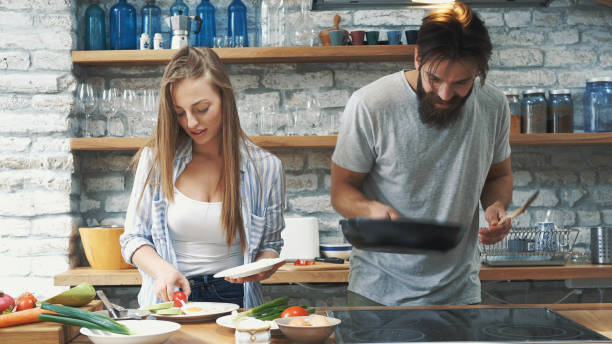 istock Young couple making dinner together at home 1176135456