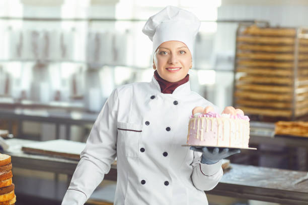 istock Confectioner with pastry cake in his hand at the bakery. 1176136583