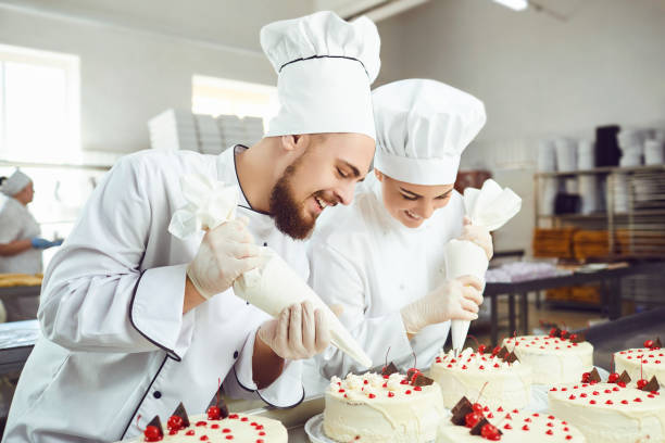 istock A confectioners squeezes liquid cream from a pastry bag. 1176136584