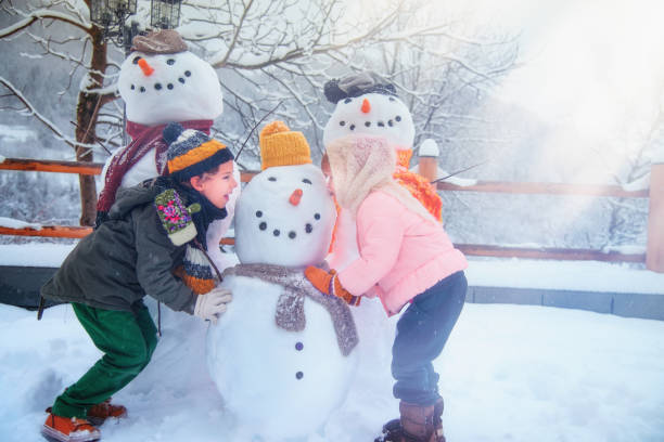 istock Happy Kids Playing with Snowmen 1176136597