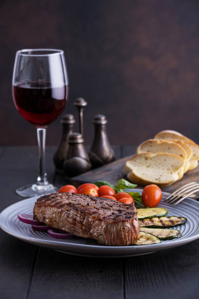 istock Grilled ribeye beef steak with red wine, vegetables and spices 1176137982