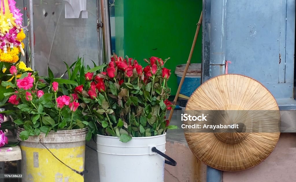 Florist Shop with Roses and Flower Wreaths Beautiful Roses Blossoms and Jasmine Wreaths or Garlands with Chinese Straw Hat at Thailand Flower Shop. Blossom Stock Photo