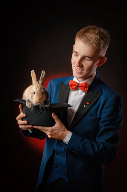 istock a young guy magician illusionist holding a hat with a rabbit 1176142812