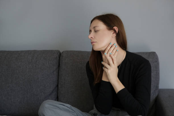 istock A picture of a young woman suffering from a sore throat or thyroid problem symptoms 1176147459