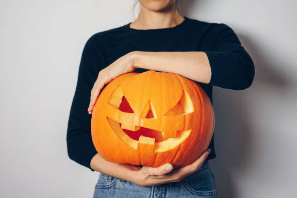 istock Woman holding a Halloween pumpkin 1176151461