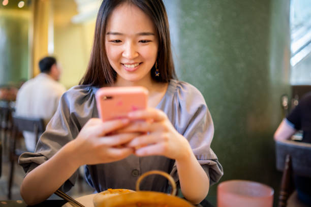 istock Cheerful Asian woman using her smartphone 1176152410