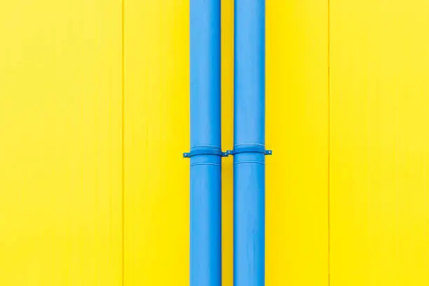 Colourful composition. Blue water-pipes on juicy yellow background