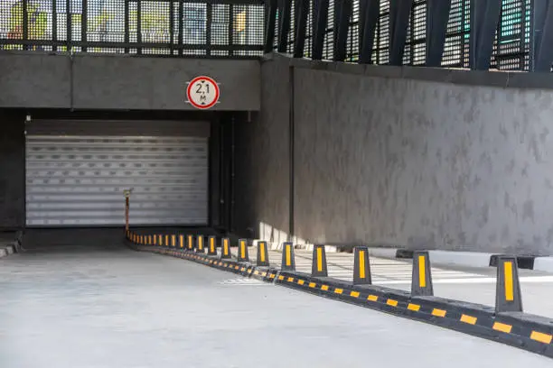 Entrance to underground garage with roller-shutter door and road dividers