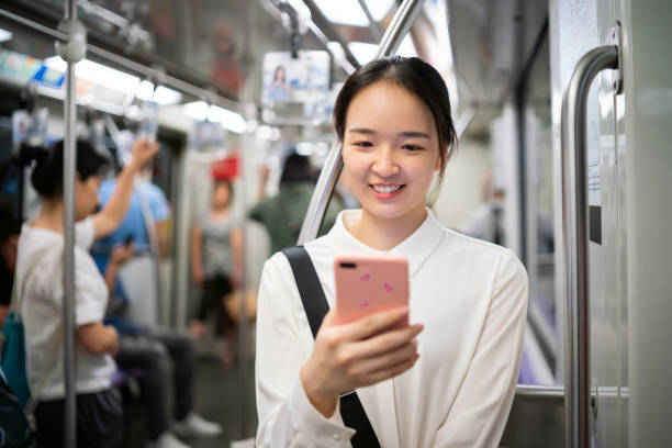istock Young Asian woman using her smartphone in metro train 1176154668