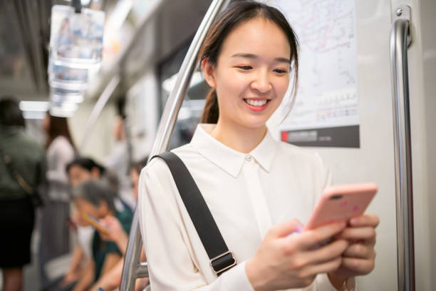 istock Young Asian woman using her smartphone in metro train 1176154691