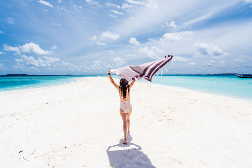Young adult woman enjoying a paradisiac beach in Maldives