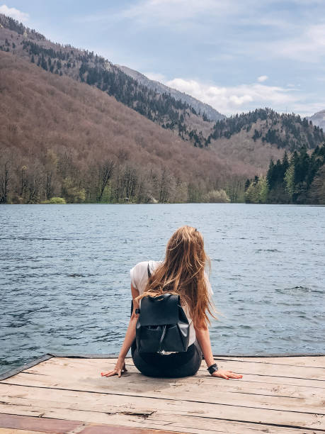 istock Woman sitting on lake dock 1176159539