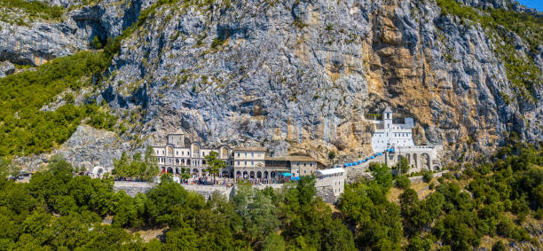 vista aérea do monastério de ostrog, igreja ortodoxa sérvia situada de encontro a um fundo quase vertical, elevado acima na rocha grande de ostroška greda, em montenegro - ostrog - fotografias e filmes do acervo