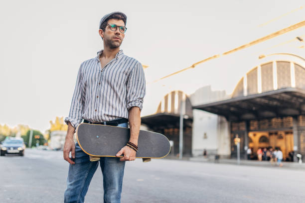 istock Modern man with skateboard standing on the street 1176162109