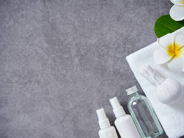 istock Beautiful spa composition with herbal compress ball and set body lotion, loofah sponge, herbal soap on gray marble background. 1176165521