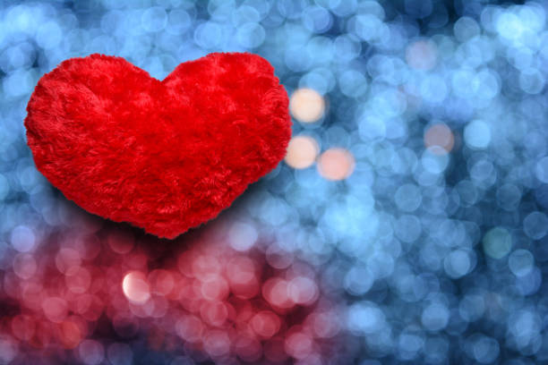 밤에 정원에서 램프에서 파란색 흐림 빛의 배경에 작은 빨간 심장 모피 베개 - romantic scene flash 뉴스 사진 이미지