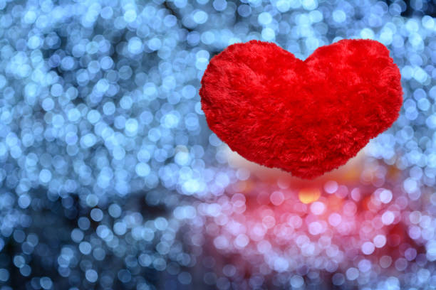 kleine rotes herz pelz kissen auf hintergrund von blauen unschärfe licht von lampe im garten in der nacht - romantic scene flash stock-fotos und bilder