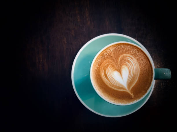 istock Coffee  Latte with Heart Design in green cup on wooden table 1176166941