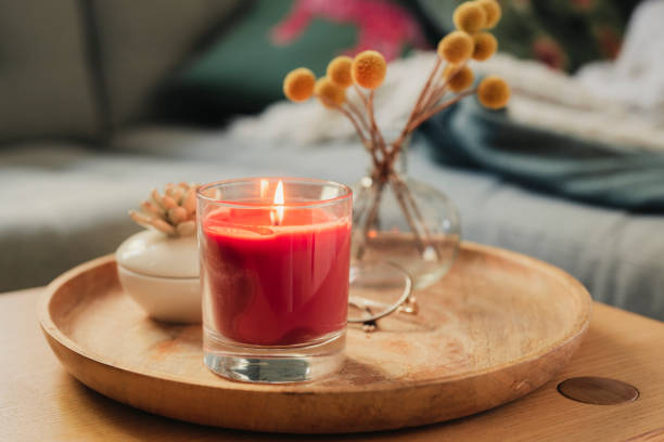 vela perfumada ardiendo en la mesa del sofá - vela equipo de iluminación fotografías e imágenes de stock