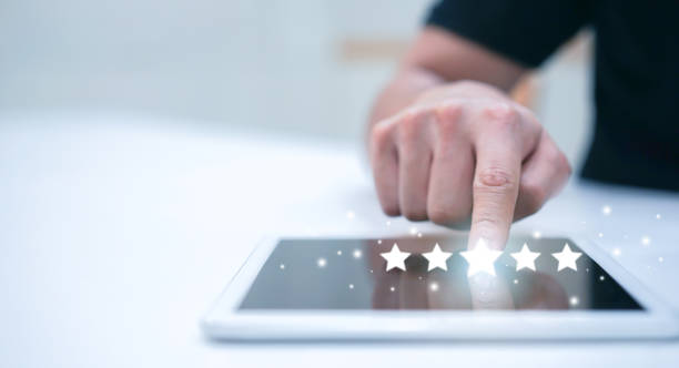 istock close up on blogger man hand pressing on digital tablet screen with five star rating feedback icon and press level three rank for giving score point to review the service , technology business concept 1176178431