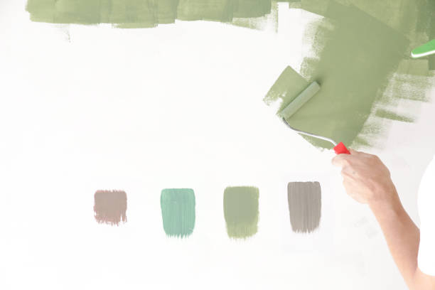 istock Paint roller. Process of painting with green paint over a white wall. 1176179614