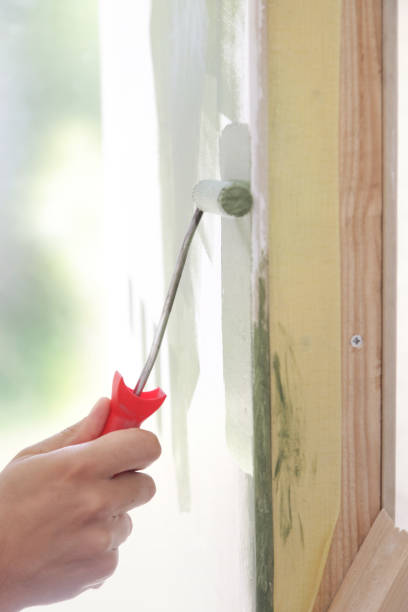 istock Paint roller. Process of painting with green paint over a white wall. 1176179681