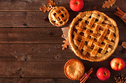 Homemade autumn apple pie, top view corner border over a rustic wood background