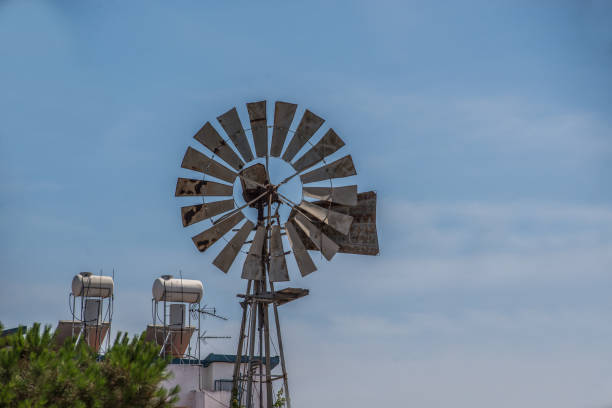 Windmill in a city environment with blue sky backdrop, daylight conditions
