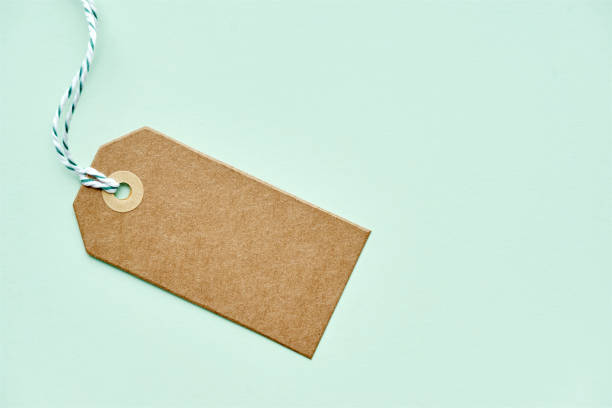 istock Blank brown gift tag with twine on green 1176184221