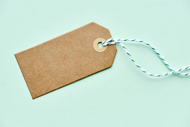 istock Blank brown gift tag with twine on green 1176184227