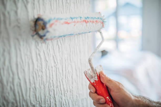 istock Painter painting walls in white color 1176185642