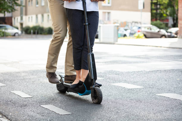 istock Couple's Standing On Electric Scooter Over The Asphalt 1176189250