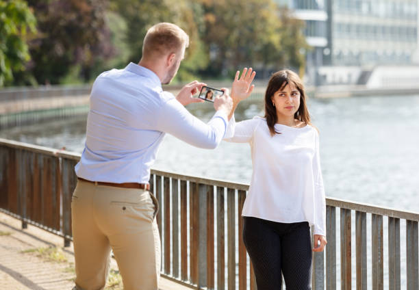 istock Woman Refusing Man Taking Her Photo On Mobile Phone 1176189303