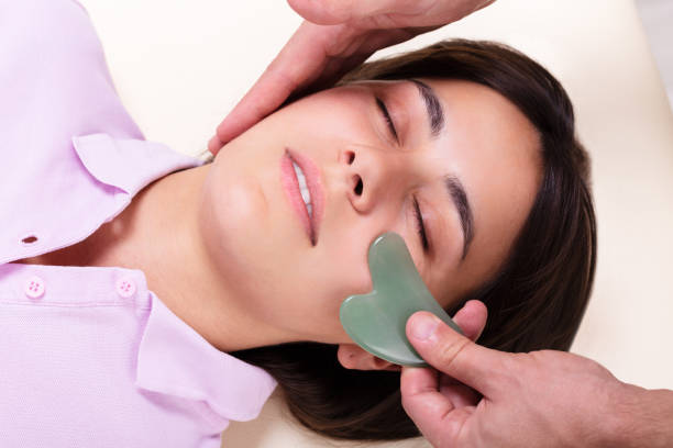 istock Woman Receiving Gua Sha Stone Massage On Her Face 1176189494