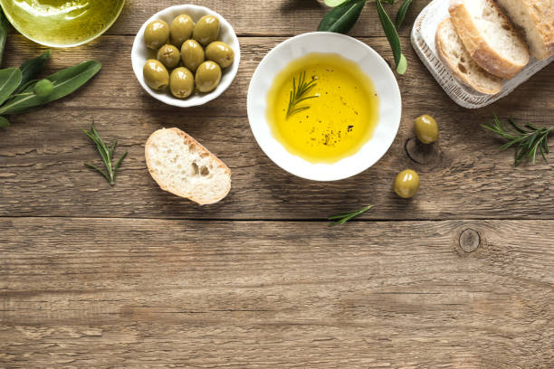 Olive Oil Olive Oil. Organic olive oil with rosemary and green olives in bowl on wooden background with copy space, healthy food concept. dipping sauce photos stock pictures, royalty-free photos & images