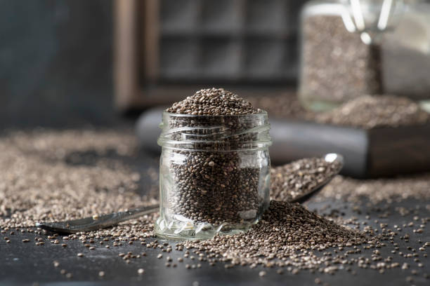 Chia seeds in glass jar, dark background, selective focus Chia seeds in glass jar, dark background, selective focus salvia hispanica plant stock pictures, royalty-free photos & images